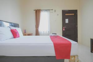 מיטה או מיטות בחדר ב-RedDoorz Syariah near Kantor Walikota Jambi