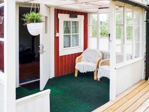 un porche cubierto con 2 sillas y una puerta en 3 person holiday home in OSKARSHAMN en Oskarshamn