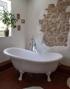 a bath tub in a bathroom with a stone wall at Kleines Häuschen im Grünen in Monheim