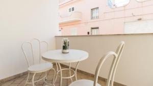 a small white table and chairs on a balcony at Italianway - Ottoventi Apartments in Lampedusa