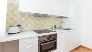 a white kitchen with a sink and a stove at Italianway - Ottoventi Apartments in Lampedusa