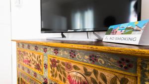 a wooden dresser with a tv and a book on it at Italianway - Ottoventi Apartments in Lampedusa