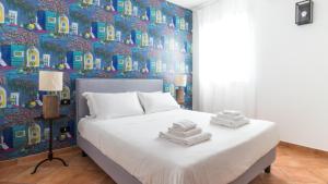 a bedroom with a bed and a wall of houses at Italianway - Ottoventi Apartments in Lampedusa
