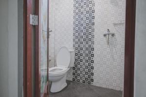 占碑市RedDoorz Syariah near Jamtos Jambi 2的带马桶和玻璃门的浴室