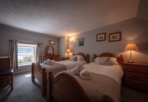 una camera da letto con due letti e una finestra di Beachcomber Cottage a Stein