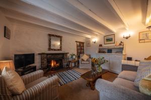 un soggiorno con due divani e un camino di Beachcomber Cottage a Stein