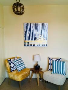 a living room with two chairs and a table with a lamp at Historic Grade 2 listed Cottage with Parking in Rye