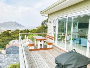 una terraza con mesa y sillas en una casa en Mount Bay en Hout Bay