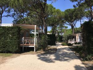 a house with a porch and trees in the background at Dune Prestige & Chalets in Bibione