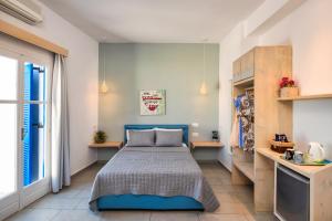 a bedroom with a blue bed and a window at Afrodete Hotel in Firostefani