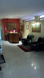 un vestíbulo con una persona sentada en una sala de espera en Hostal Guzman El Bueno by gaiarooms en León