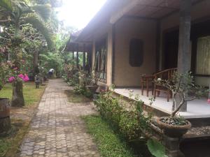 Una pasarela junto a un edificio con plantas. en Batan Duren House, en Ubud 7 fotos más