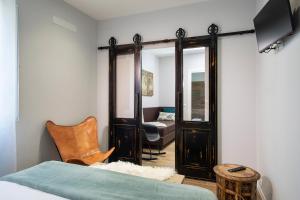 een slaapkamer met een bed, een stoel en een spiegel bij Affittacamere I Canneggiatori in Abbadia San Salvatore