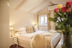 a bedroom with a bed and a vase of flowers at Palmotta Palace in Dubrovnik
