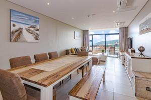 巴利托的住宿－Suite 501, Zimbali Suites，用餐室配有大型木桌和椅子