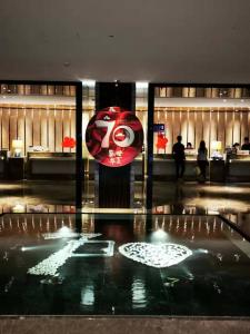 a lobby with a red and white sign in a building at Fulitai International Hotel in Yantai