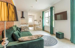 un soggiorno con divano verde e TV di Apart-Invest Apartament Glamoure a Szklarska Poręba