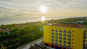 a yellow building with the ocean in the background at Fivitel Hoi An Hotel in Hoi An