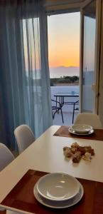 een tafel met borden en uitzicht op de oceaan bij Evripus Suites in Kastraki Naxou