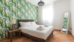 a bedroom with a bed with a floral wallpaper at Italianway - Ottoventi Apartments in Lampedusa