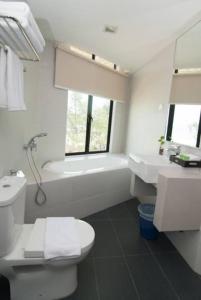 a bathroom with a toilet and a tub and a sink at Samsuria Beach Resort & Residence in Cherating