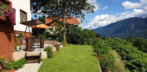 ein Haus mit einem Garten mit grünem Gras und Blumen in der Unterkunft Comfort and Views in Hermagor