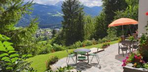 a patio with a table and chairs and an umbrella at Comfort and Views in Hermagor