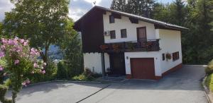 ein weißes Haus mit einem Balkon mit Blumen darauf in der Unterkunft Comfort and Views in Hermagor