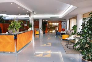 a lobby with a reception desk and potted plants at Hotel Capricho in Cala Ratjada