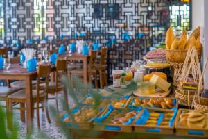 a long table with food on it with tables and chairs at Fivitel Hoi An Hotel in Hoi An