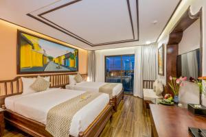 a hotel room with two beds and a large window at Fivitel Hoi An Hotel in Hoi An