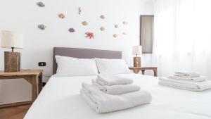 a bedroom with a white bed with towels on it at Italianway - Ottoventi Apartments in Lampedusa