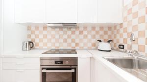 a white kitchen with a sink and a stove at Italianway - Ottoventi Apartments in Lampedusa