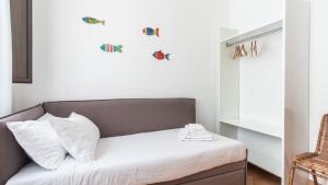 a small bedroom with a bed with white sheets at Italianway - Ottoventi Apartments in Lampedusa