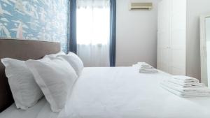 a bedroom with a white bed with white pillows at Italianway - Ottoventi Apartments in Lampedusa