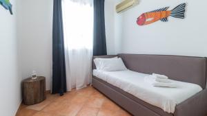 a bed in a room with a fish on the wall at Italianway - Ottoventi Apartments in Lampedusa