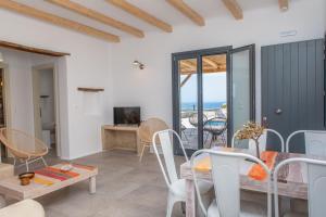 a living room with a table and chairs and a view of the ocean at Mikri Villas in Mikri Vigla