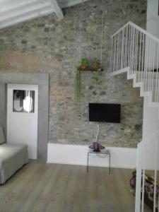 a living room with a stone wall with a flat screen tv at Villa Aruch in Florence