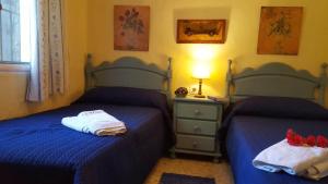 two beds in a bedroom with blue sheets and stuffed animals on them at La Morera, El Palmar in El Palmar +14 photos