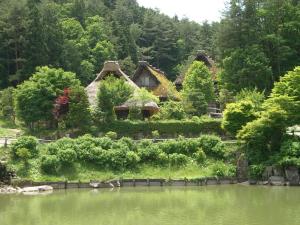 a house sitting on the side of a lake at BEYOND HOTEL Takayama 1st in Takayama
