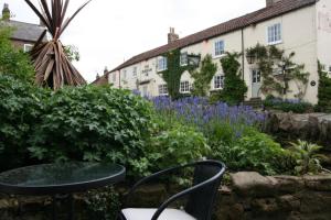 a garden with a table and chairs in front of a building at Hawthorn in Crayke YO61 4TE in York