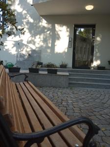 una panca di legno seduta di fronte a un edificio di Guesthouse Odesos a Sozopol
