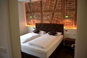 a bedroom with a bed with a brick wall at ROSER Suiten in Gengenbach +70 photos