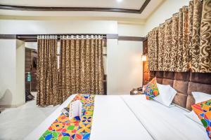 a bedroom with a bed and a window with curtains at FabHotel Santoor Geeta Bhawan Square in Indore +33 photos