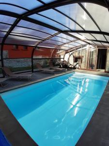 a swimming pool in a building with a train in the background at Hotel Sesué in Sesué