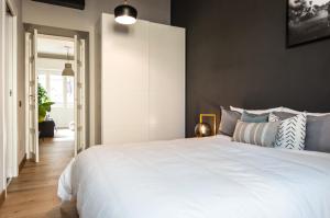 1 dormitorio con 1 cama blanca grande con almohadas azules en Calìxa, en Cagliari