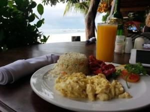 a plate of food on a table with a drink at Mecaja Beach House in Roxas