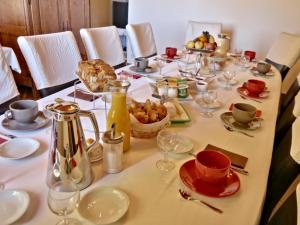 una mesa con comida y bebidas. en Le Pas de L'Ane Chambres d'hôtes, en Saint-Ondras