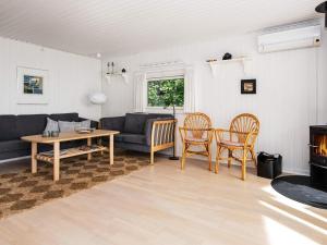 ein Wohnzimmer mit einem Sofa, einem Tisch und Stühlen in der Unterkunft 6 person holiday home in Bjert in Binderup Strand