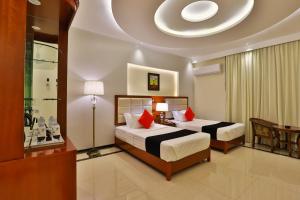 Dreams Houses furnished Suites في تبوك: غرفة نوم بسريرين ومخدات حمراء